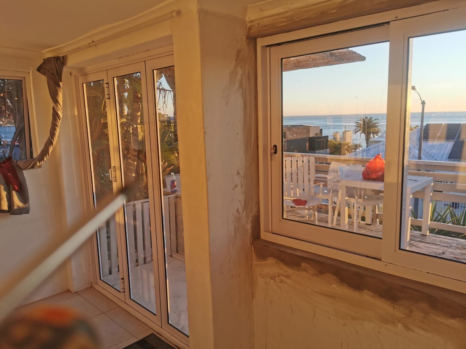 White aluminium window and glass door overlooking the coast