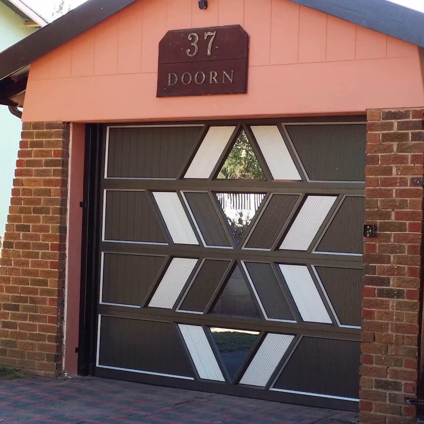 Custom black aluminium garage door with geometric glass details